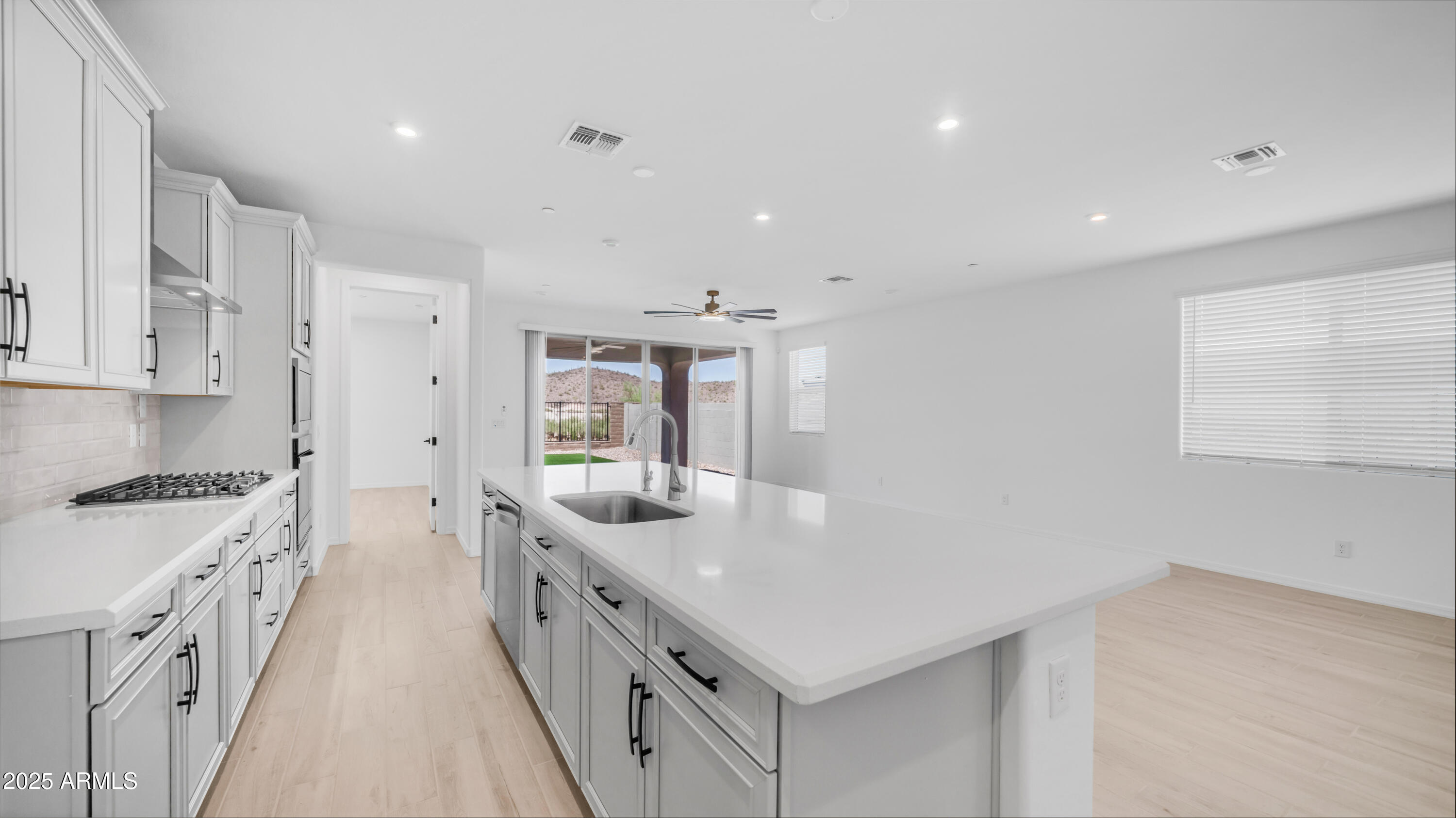 13362 West Eagle Feather Road Peoria, AZ 85383 - Photo 17 of 32 a kitchen with stainless steel appliances sink stove and cabinets