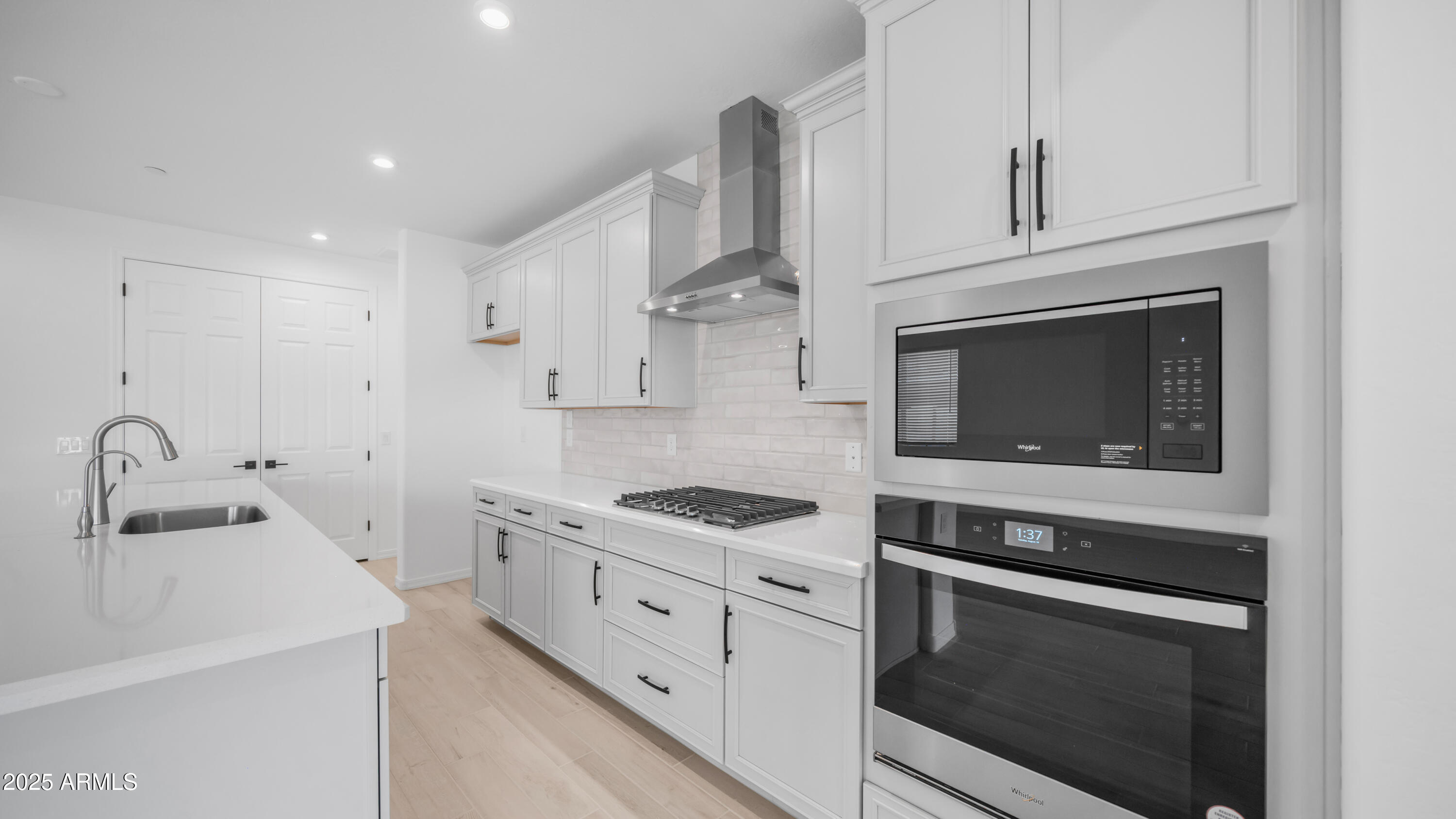 13362 West Eagle Feather Road Peoria, AZ 85383 - Photo 18 of 32 a kitchen with granite countertop white cabinets and black appliances