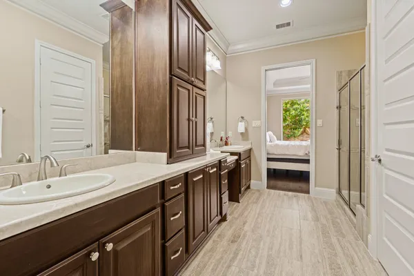 a spacious bathroom with a double vanity sink a mirror and a shower