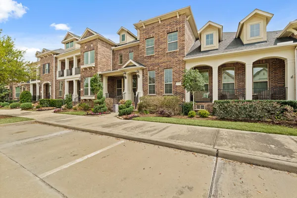 front view of a brick house with a yard