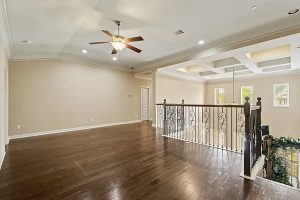 a view of a hallway with wooden floor and staircase