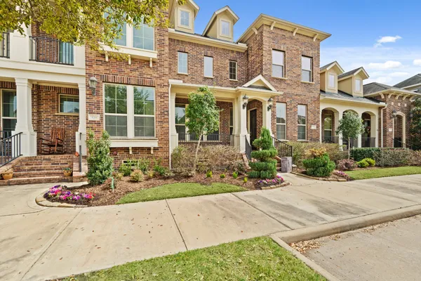 front view of a brick house with a bench in front of it