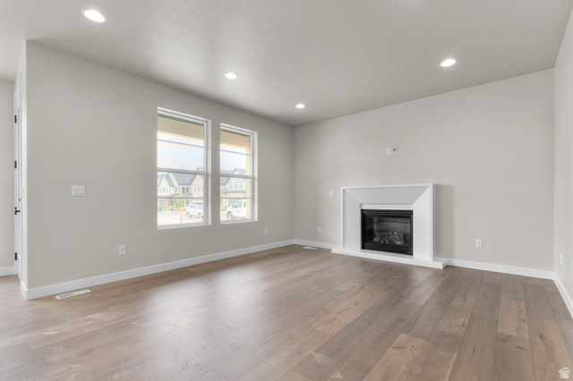 1567 North 3250 West Provo, UT 84601 - Photo 8 of 22 Spacious living area featuring wood-finish flooring, recessed lighting, and a modern fireplace with a white surround