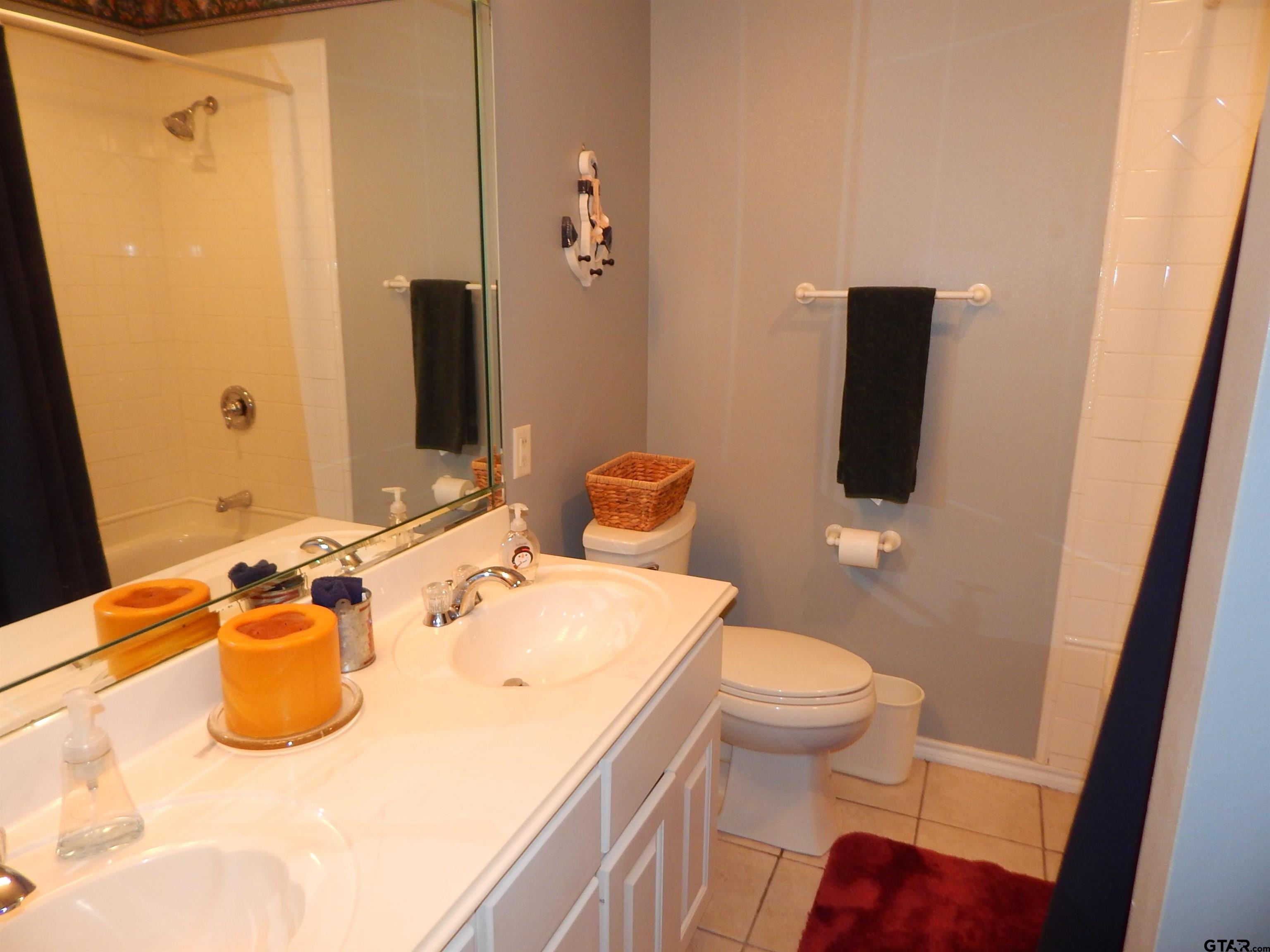 1106 Tall Timbers Road Gilmer, TX 75645 - Photo 20 of 28 a bathroom with a sink toilet and mirror