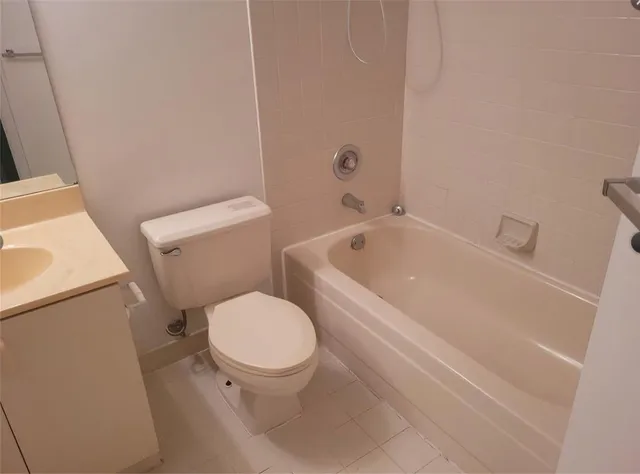 a white toilet sitting next to a bath tub