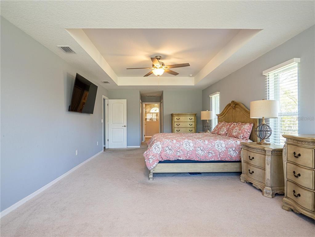 10688 Southwest 129th Terrace Road Dunnellon, FL 34432 - Photo 19 of 35 a bedroom with a bed dresser and a flat tv screen