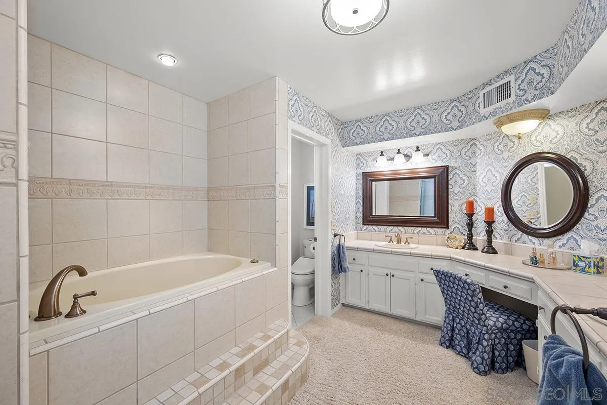 3828 Riviera Drive, Unit 2B San Diego, CA 92109 - Photo 41 of 74 a bathroom with a tub a double vanity sink and a mirror