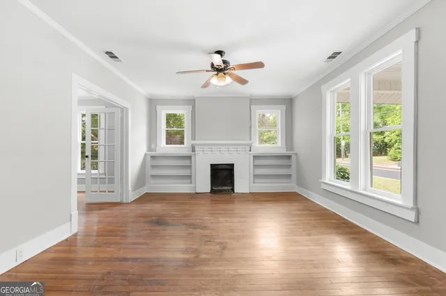 a view of a livingroom with wooden floor fireplace and a window