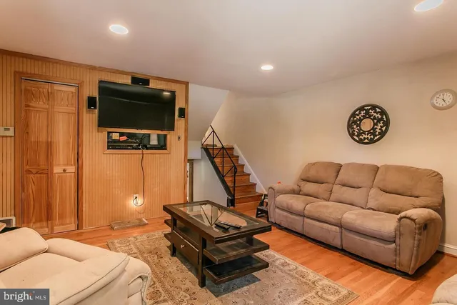 a living room with furniture a flat screen tv and a window