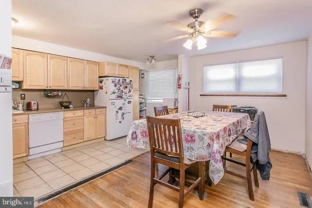a kitchen with a table chairs a sink dishwasher window and cabinets