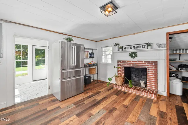 a view of a livingroom with a fireplace wooden floor and window