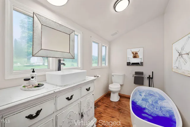 a bed sitting in a spacious bedroom next to a window