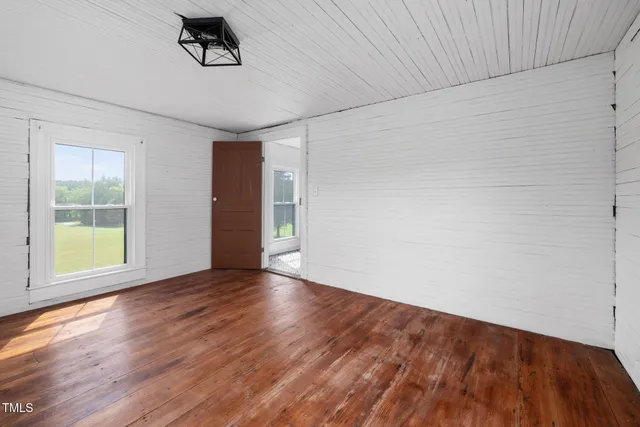 an empty room with windows and a fireplace