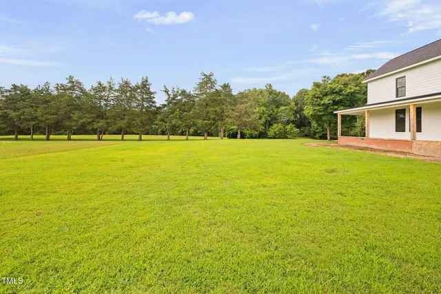 a view of a backyard with a garden and deck