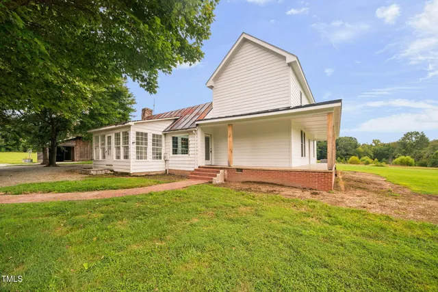 a view of a house with backyard and tree