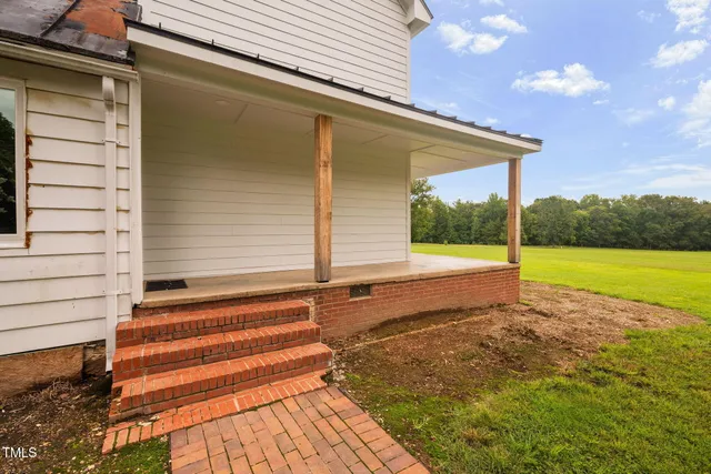 a view of a back yard of the house with a yard