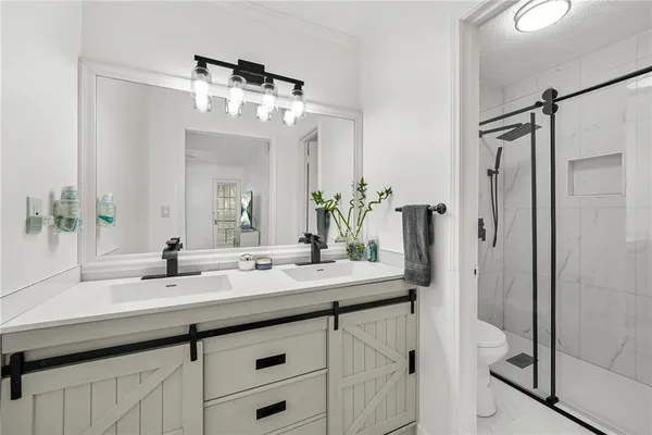a bathroom with a double vanity sink mirror and shower