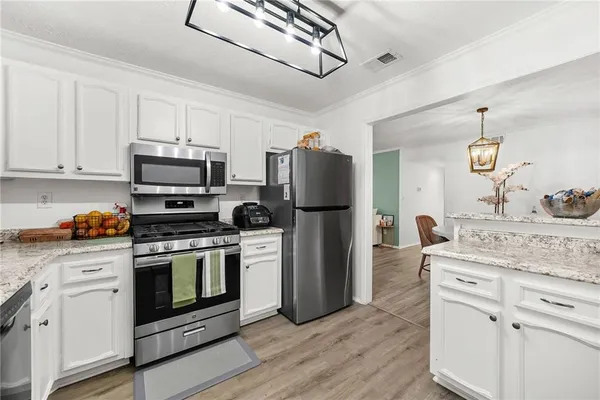 a kitchen with white cabinets and stainless steel appliances