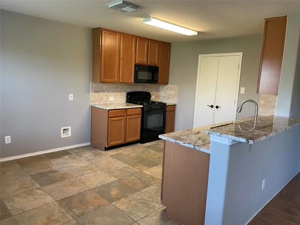 a kitchen with a sink stove top oven and cabinets
