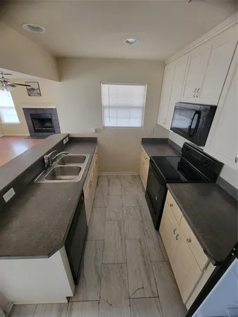 a kitchen with a sink appliances and cabinets