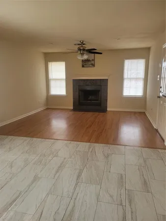 an empty room with windows and fireplace