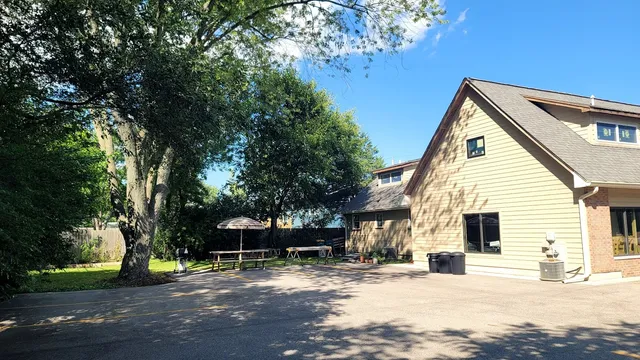 a view of a house with a yard and large tree