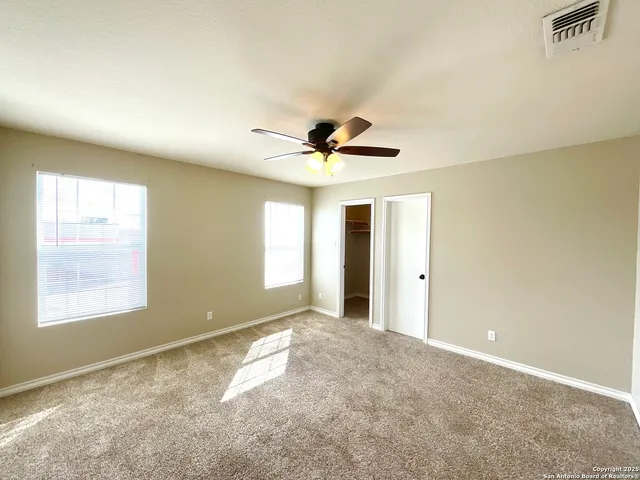 a view of a livingroom with a ceiling fan and window