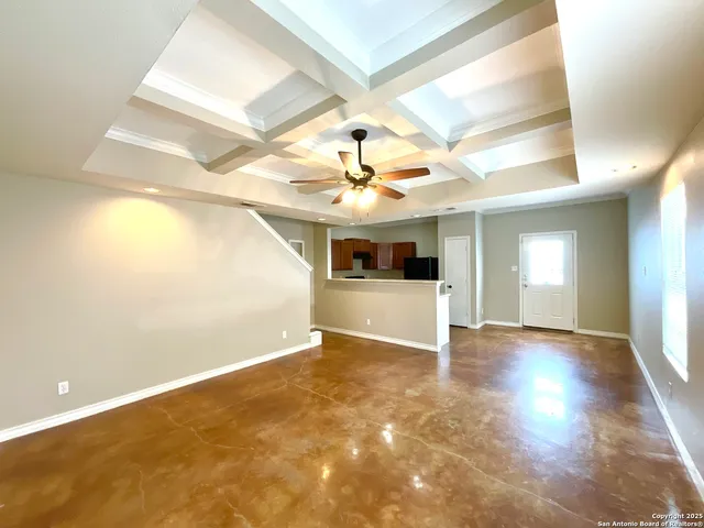 a view of a big room with wooden floor and windows
