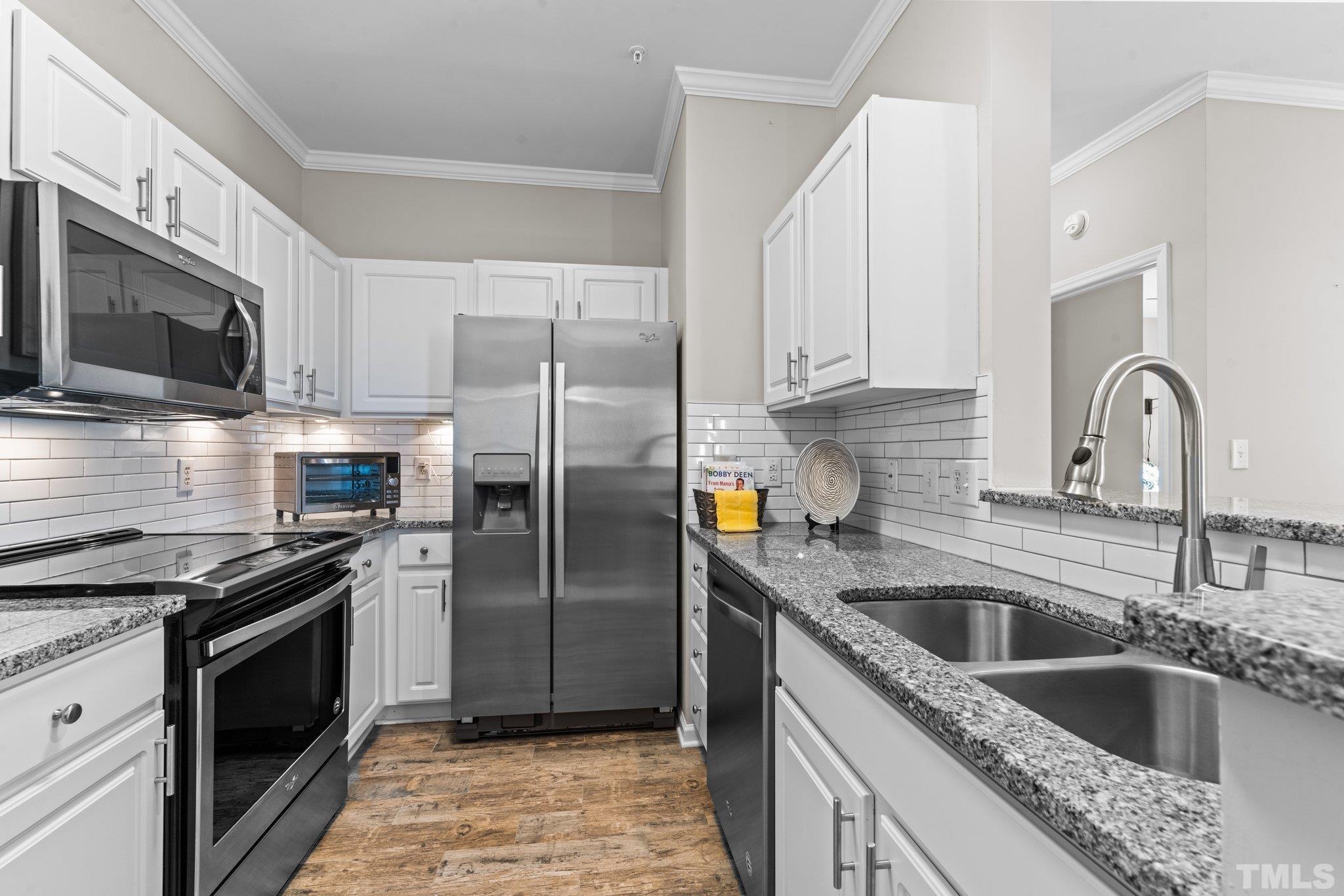 710 North Person Street, Unit 202 Raleigh, NC 27604 - Photo 11 of 33 a kitchen with granite countertop a sink stainless steel appliances and cabinets