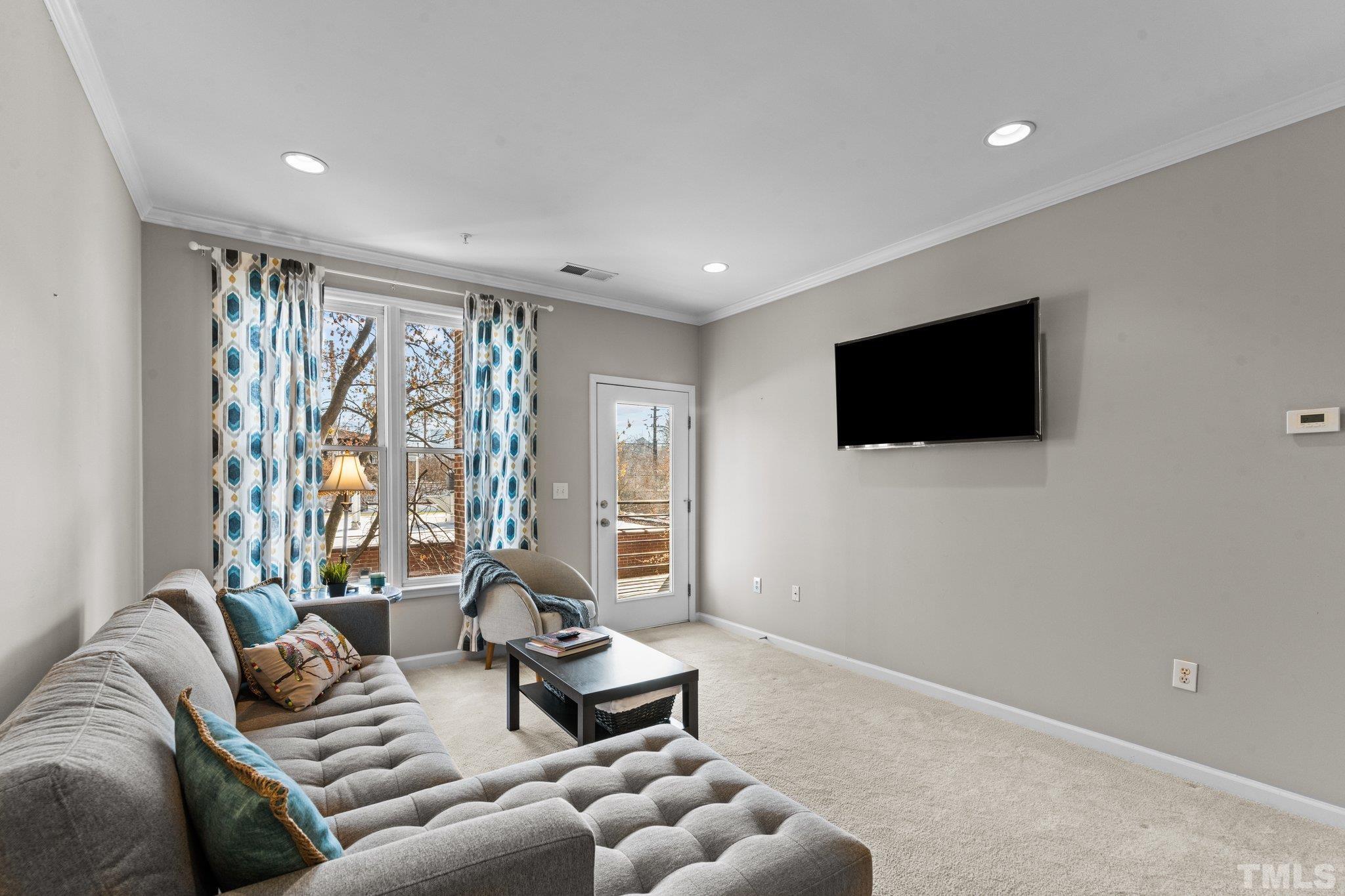 710 North Person Street, Unit 202 Raleigh, NC 27604 - Photo 14 of 33 a living room with furniture a flat screen tv and a large window