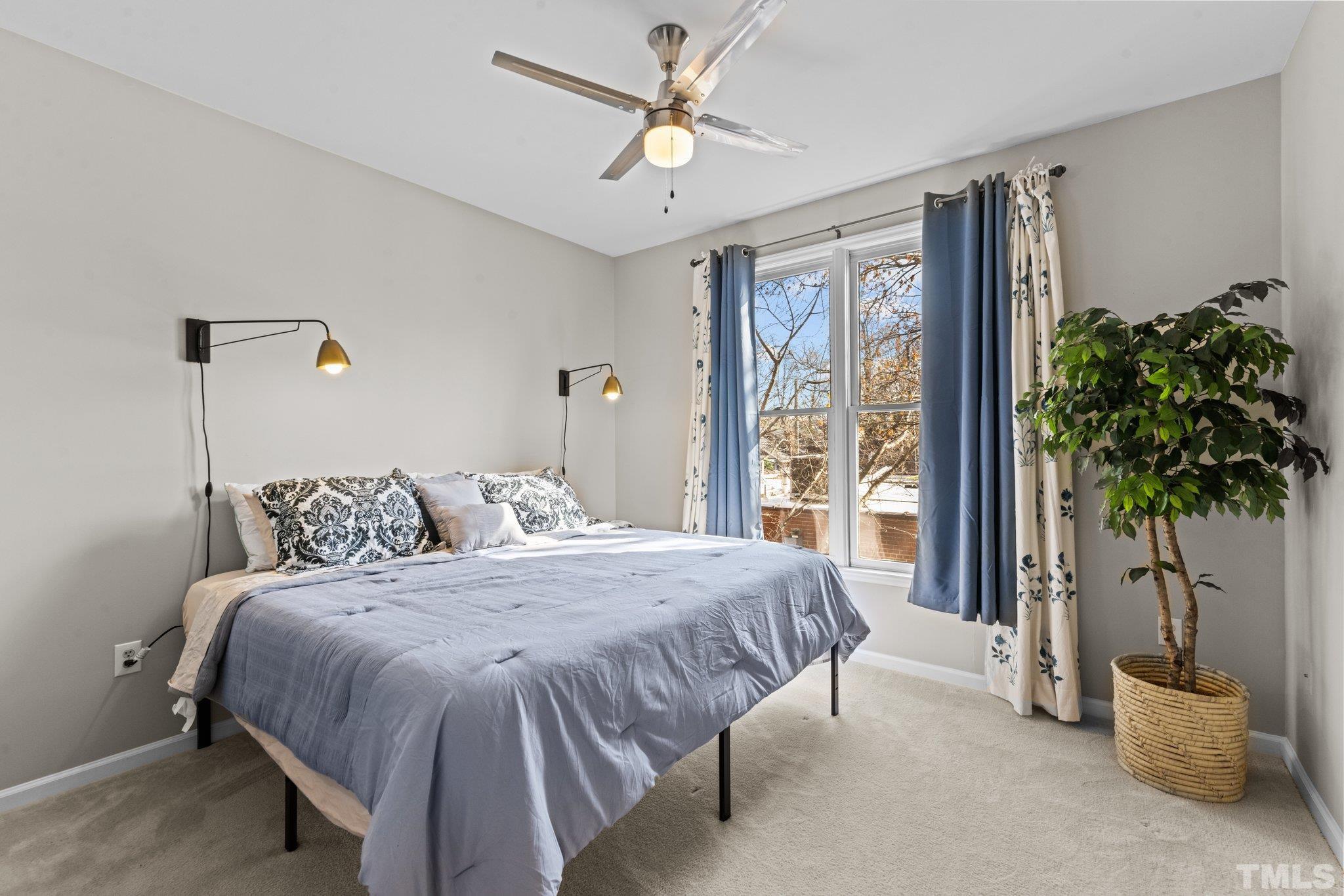 710 North Person Street, Unit 202 Raleigh, NC 27604 - Photo 24 of 33 a bedroom with a large bed and a potted plant