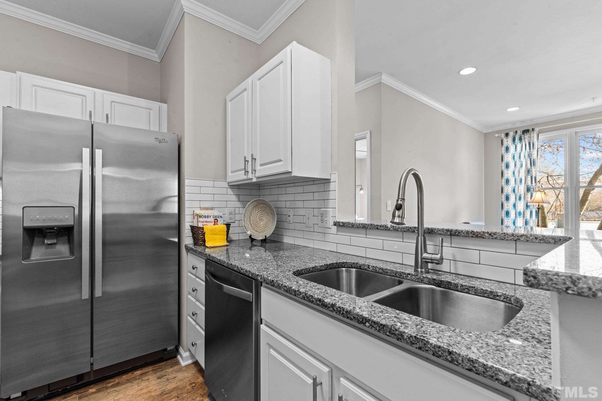 710 North Person Street, Unit 202 Raleigh, NC 27604 - Photo 9 of 33 a kitchen with a refrigerator sink and cabinets