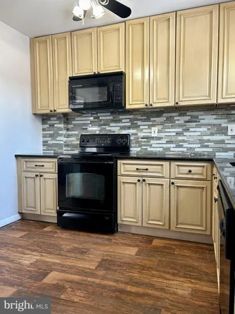 a kitchen with granite countertop a stove and a microwave