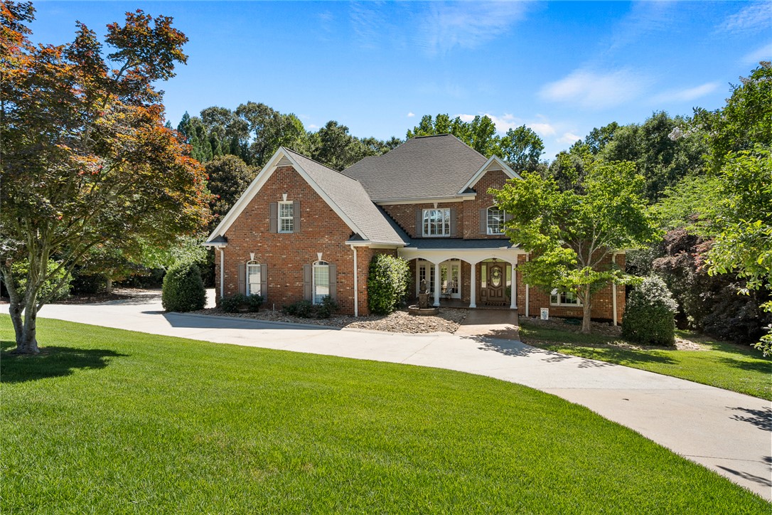 200 Graylyn Drive Anderson, SC 29621 - Photo 1 of 48 Mature trees frame a charming brick residence with an inviting front porch and a sweeping driveway.