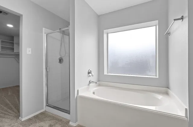 a white bath tub sitting next to a shower