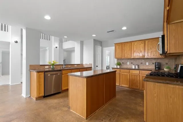 a kitchen with stainless steel appliances granite countertop a stove a sink and a refrigerator