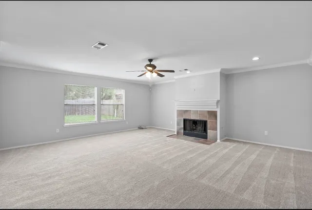 a view of an empty room with a fireplace and a window