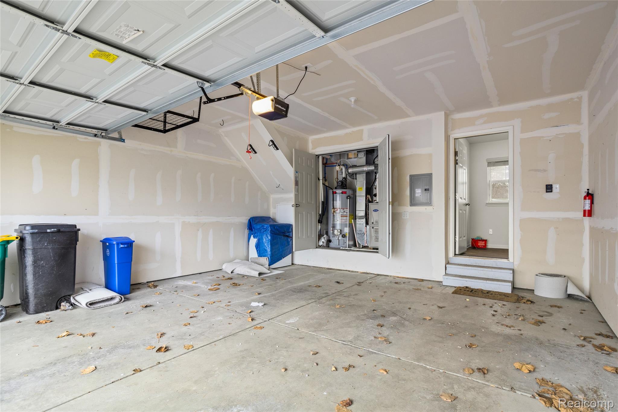 478 North Wixom Road Wixom, MI 48393 - Photo 24 of 26 Garage featuring electric panel, water heater, heating unit, and a garage door opener