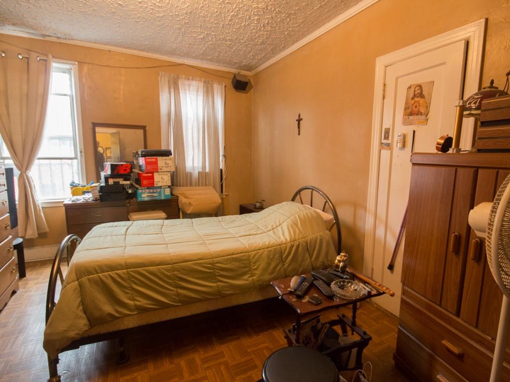 426 Ave Y Brooklyn, NY 11223 - Photo 13 of 25 a bedroom with a bed and wooden floor