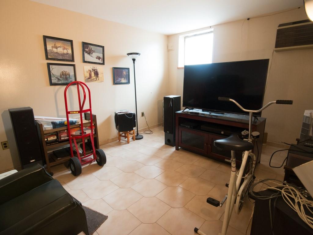 426 Ave Y Brooklyn, NY 11223 - Photo 10 of 25 a room with gym equipment and a flat screen tv