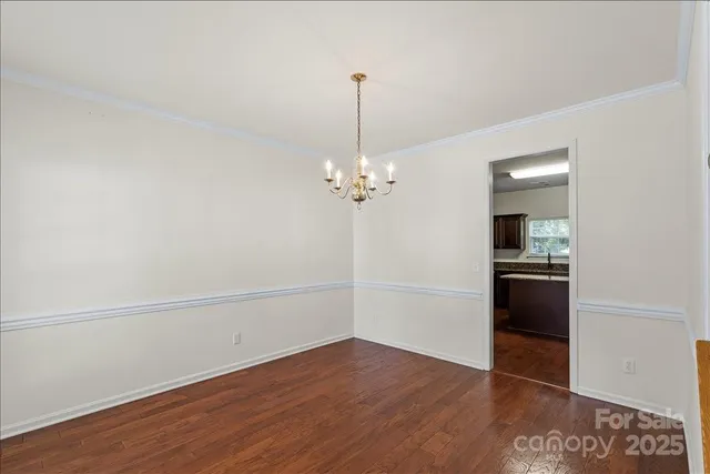 wooden floor in an empty room with a kitchen