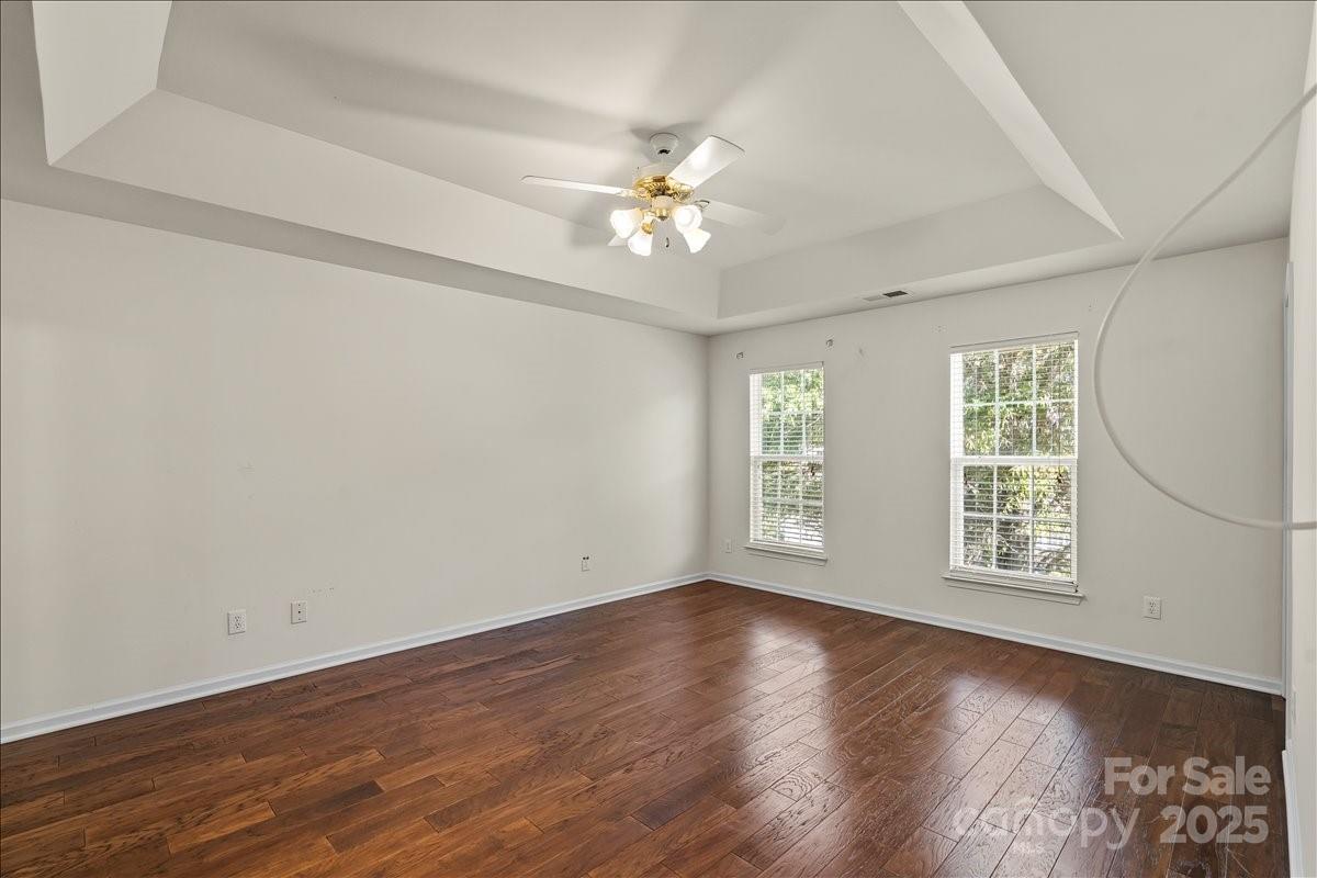 11938 Harmon Lane Pineville, NC 28134 - Photo 18 of 36 an empty room with wooden floor chandelier fan and windows