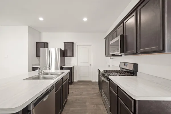 a kitchen with stainless steel appliances granite countertop a sink stove and refrigerator