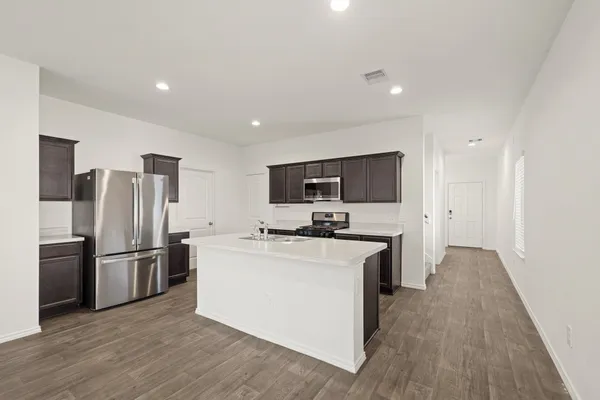 a kitchen with stainless steel appliances a refrigerator stove a sink and a oven