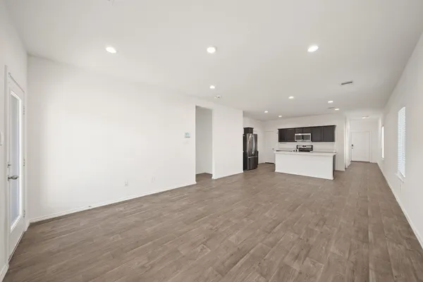 a view of empty room with wooden floor