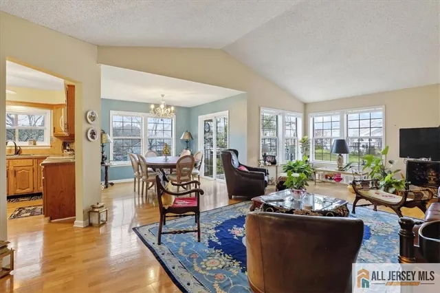a living room with furniture a dining table and a floor to ceiling window