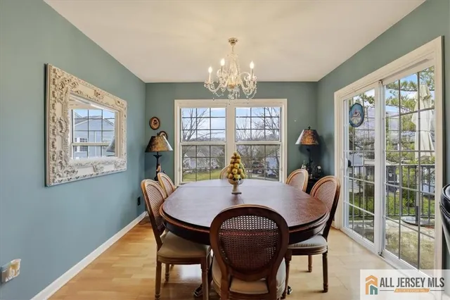 a view of a dining room with furniture a chandelier and wooden floor