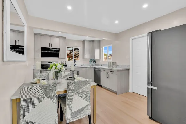 a kitchen with microwave a refrigerator and chairs