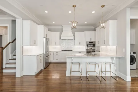 a kitchen with kitchen island white cabinets and stainless steel appliances
