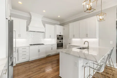 a kitchen with granite countertop a sink appliances cabinets and furniture